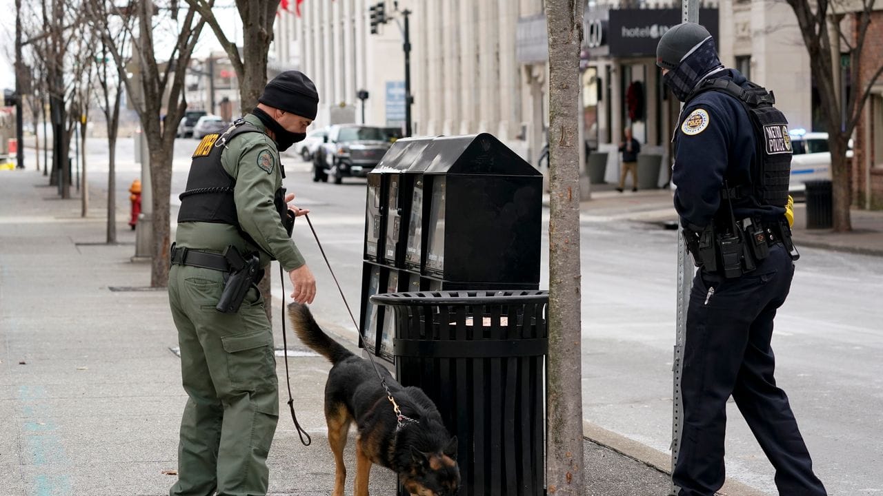 Ein Mitarbeiter der Hundestaffel (K9) sucht das Gebiet mit Bombenspürhunden ab, um mögliche weitere Explosionen auszuschließen. Ein Mitarbeiter der Hundestaffel (K9) sucht das Gebiet mit Bombenspürhunden ab, um mögliche weitere Explosionen auszuschließen.