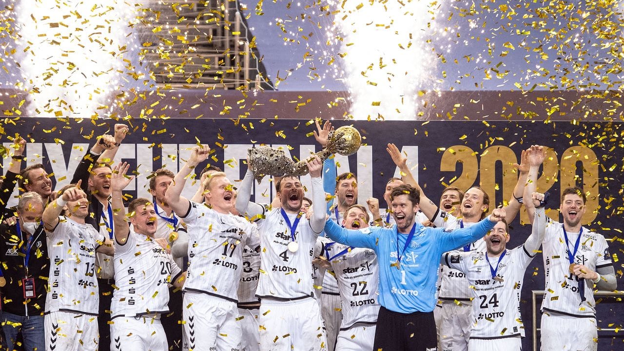 Die Spieler von THW Kiel jubeln im Konfettiregen mit dem Pokal.