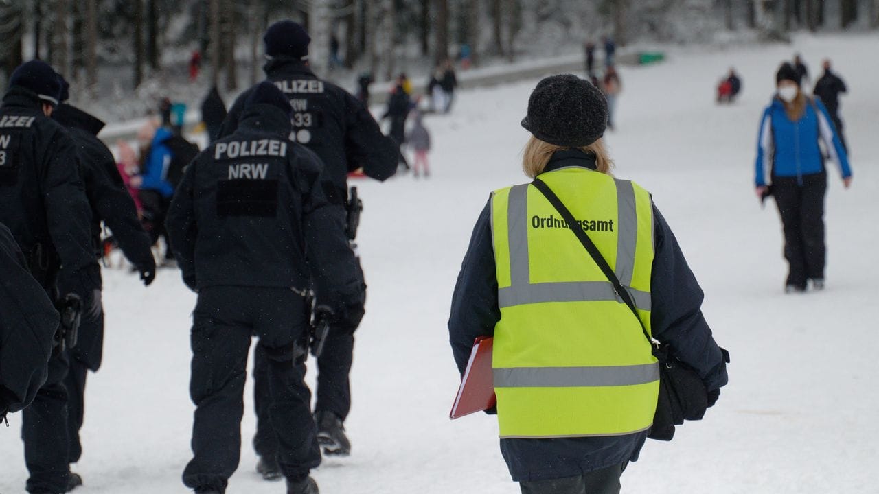Polizisten und eine Mitarbeiterin des Ordnungsamtes stehen auf einer Piste im Skigebiet in Winterberg. Polizisten und eine Mitarbeiterin des Ordnungsamtes stehen auf einer Piste im Skigebiet in Winterberg.