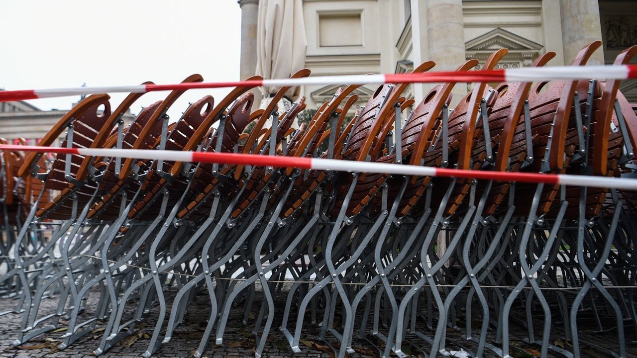 Auf dem Gendarmenmarkt in Berlin stehen zusammengestapelte Stühle hinter einem Absperrband. Auf dem Gendarmenmarkt in Berlin stehen zusammengestapelte Stühle hinter einem Absperrband.