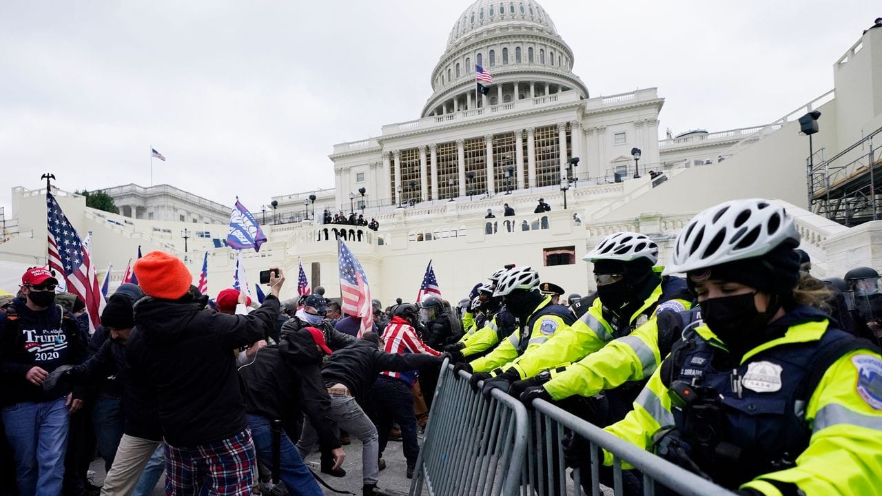 Trump-Unterstützer versuchen eine Absperrung vor dem Kapitol zu durchbrechen.