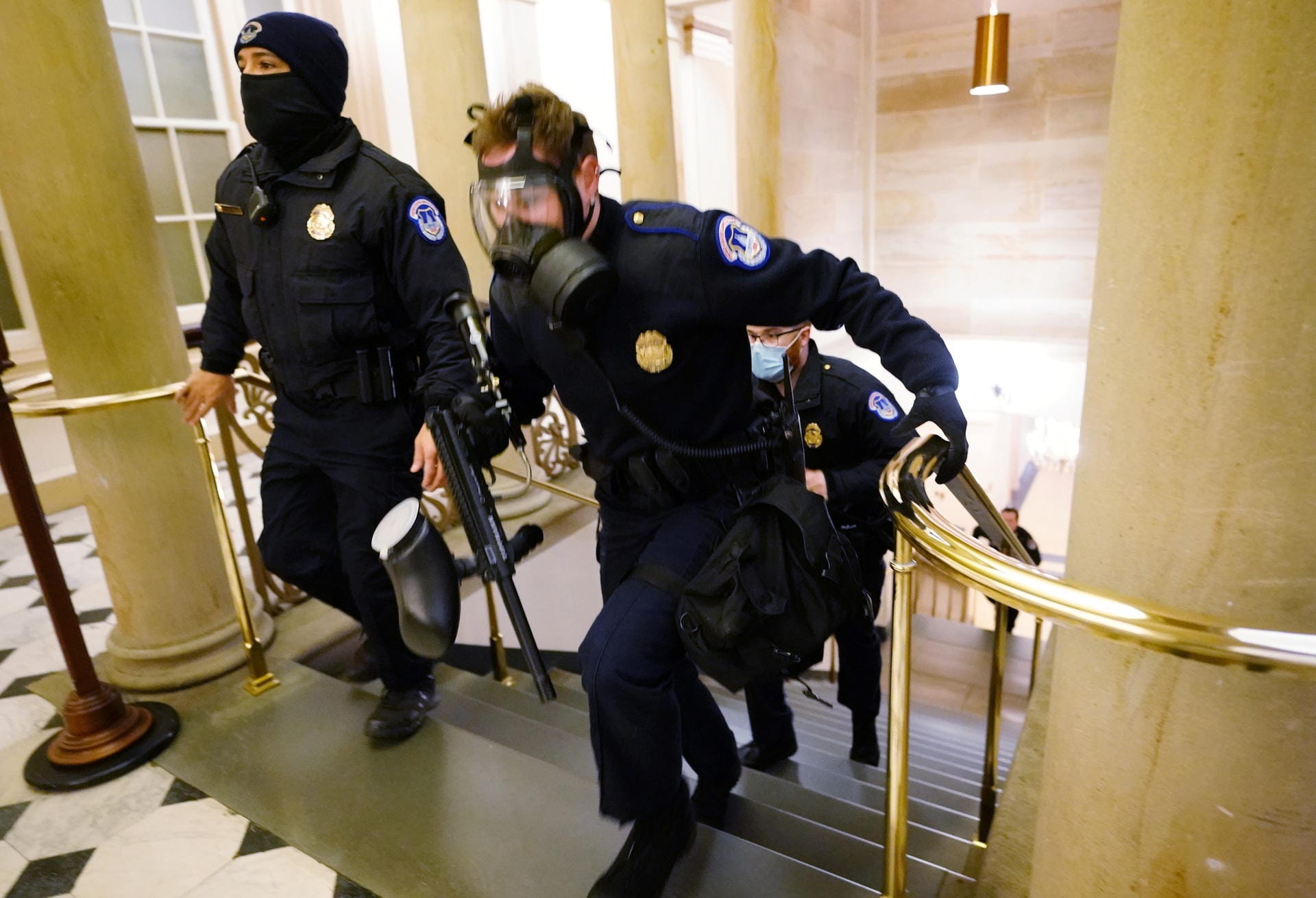 Polizisten eilen in Schutzmontur zur Unterstützung durch die Flure des Kapitols.