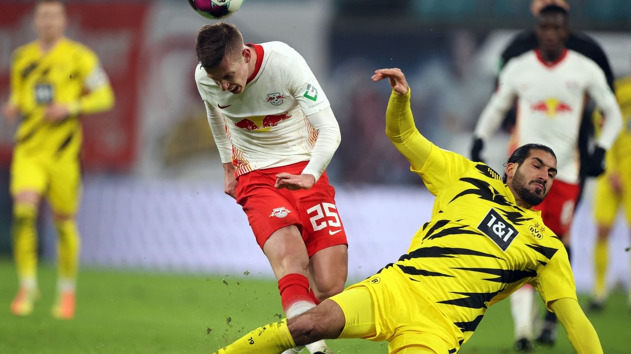 Leipzigs Dani Olmo (l) und Dortmunds Emre Can kämpfen um den Ball.