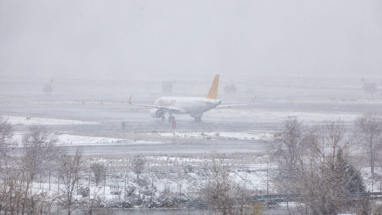 Ein Passagierflugzeug steht bei dichtem Schneefall auf dem Flughafen Madrid-Barajas.