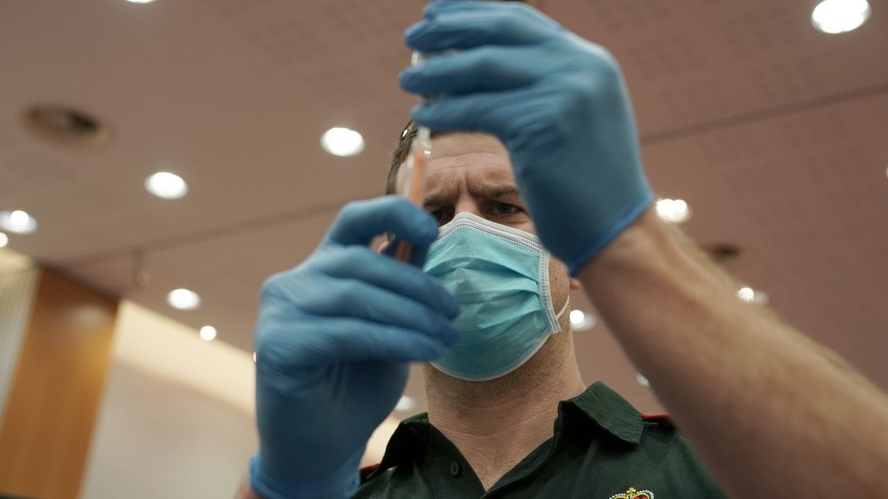 Ein Mitarbeiter füllt eine Spritze mit einem Corona-Impfstoff im NHS-Impfzentrum, das im Centre for Life am Times Square in Newcastle eingerichtet wurde.