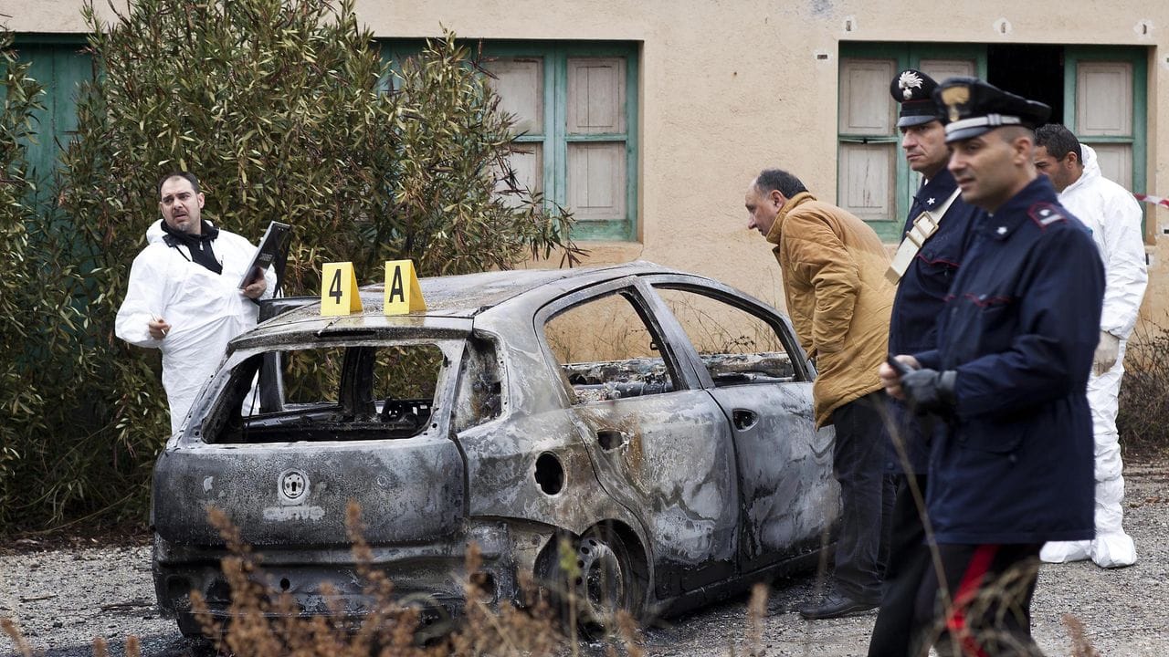 Ermittler arbeiten an einem verbrannten Auto, in dem drei verbrannte Leichen in Cassano allo Ionio, Provinz Kalabrien, Süditalien, gefunden wurden.