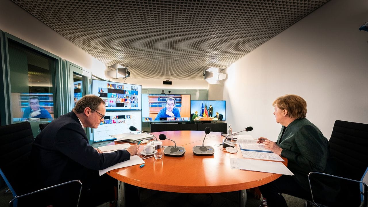 Bundeskanzlerin Angela Merkel und Berlins Regierender Bürgermeister Michael Müller sitzen gemeinsam im Kanzleramt bei der Videokonferenz mit den Ministerpräsidenten der Länder.