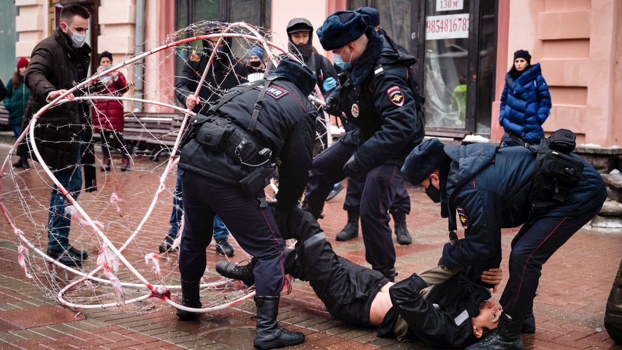 Polizeibeamte ziehen den Oppositionsaktivisten Pawel Krysewitsch aus einer Stacheldrahtkugel.