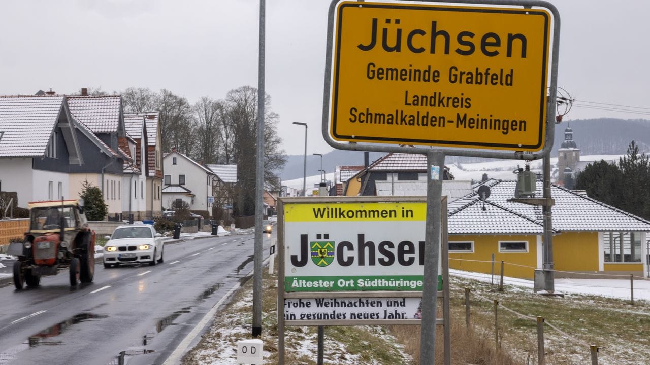 Ein Traktor fährt am Ortseingangsschild von Jüchsen vorbei. Ein Traktor fährt am Ortseingangsschild von Jüchsen vorbei.