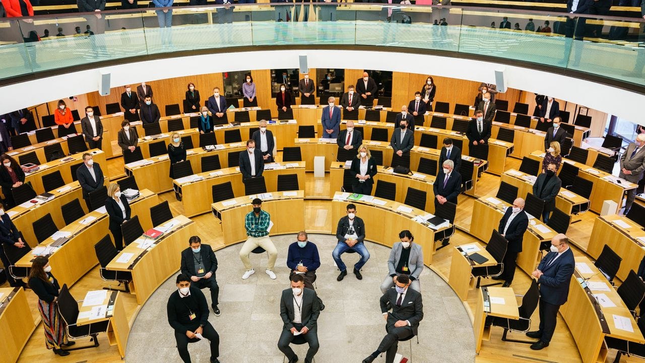 Angehörigen und Überlebende des Hanauer Anschlags sitzen bei der Gedenkveranstaltung im Landtag in Wiesbaden.