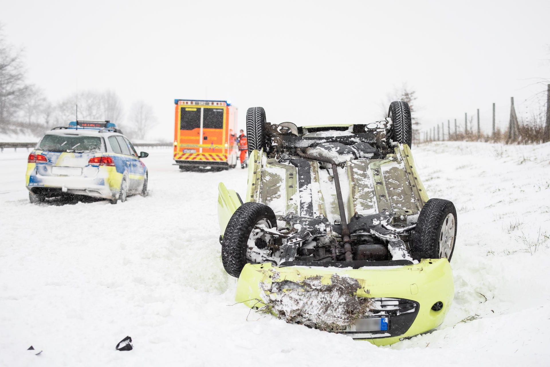 Ein Fahrzeug liegt auf der verschneiten A2 im Graben: Allein in Nordrhein-Westfalen rückte die Polizei wegen des Winterwetters zu 720 Einsätzen innerhalb von 24 Stunden aus.