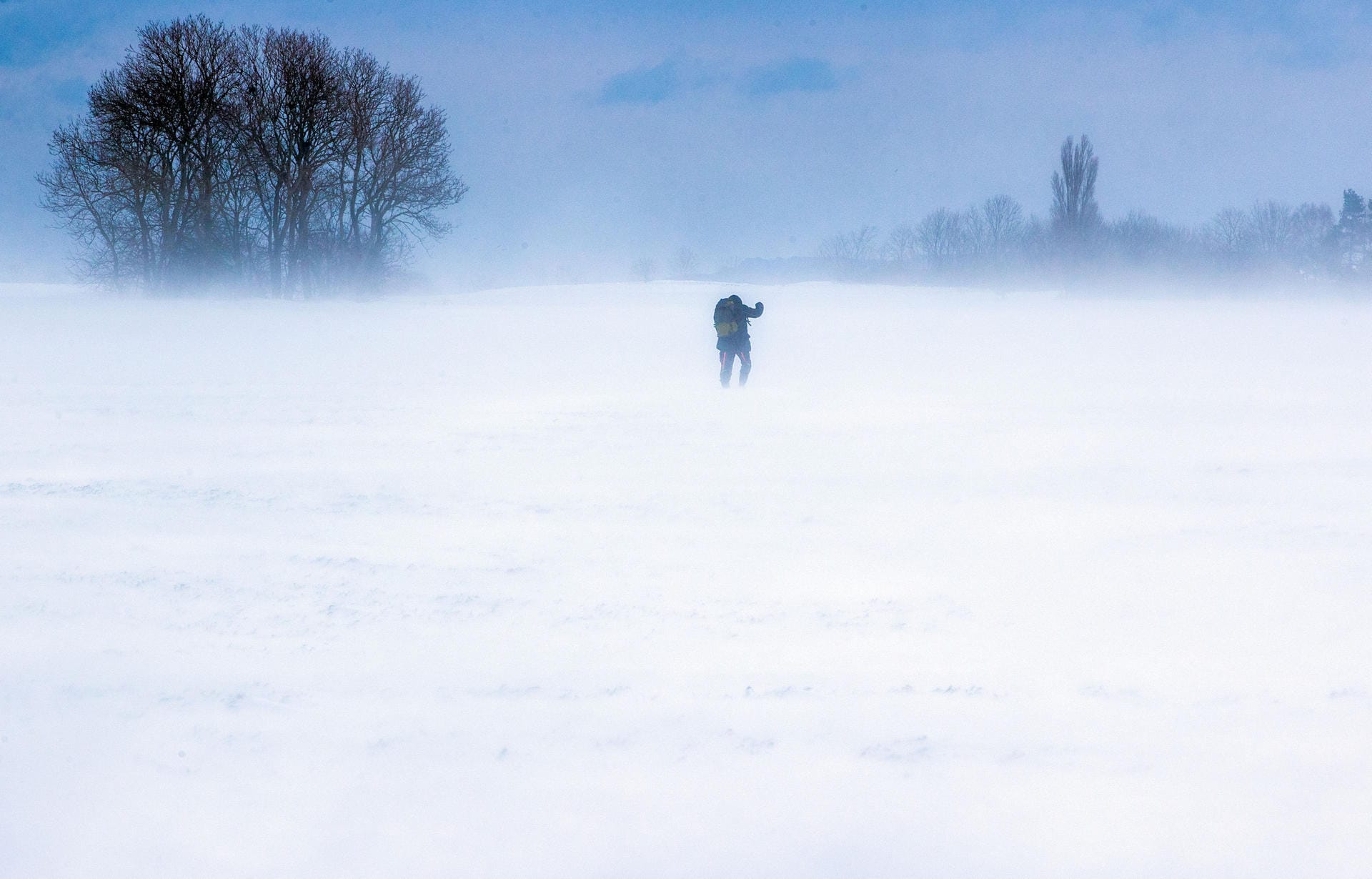 Ein Mann läuft über einen verschneiten Acker auf der Insel Rügen: Starker Wind sorgte im Norden der Insel für Schneeverwehungen.