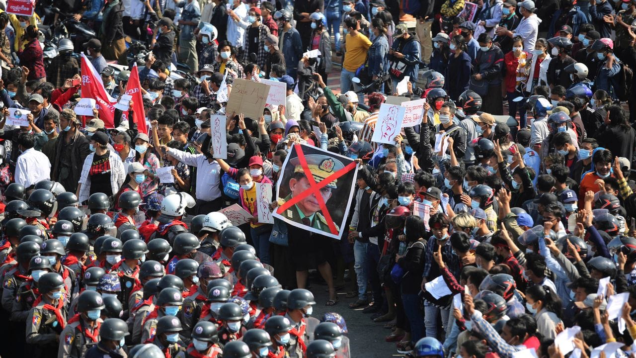 Demonstranten zeigen in Naypyitaw den Dreifingergruß und ein durchgestrichenes Foto des Generals Min Aung Hlaing.