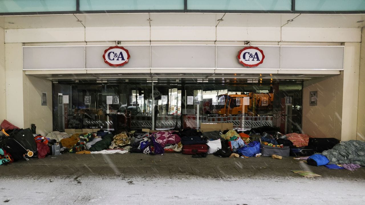 Obdachlose Menschen haben ihren Schlafplatz im Eingang eines Kaufhauses in der Innenstadt aufgeschlagen.