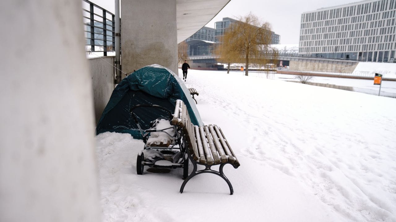 Das Zelt eines Obdachlosen steht bei kalten Temperaturen am Spreeufer im Schnee.