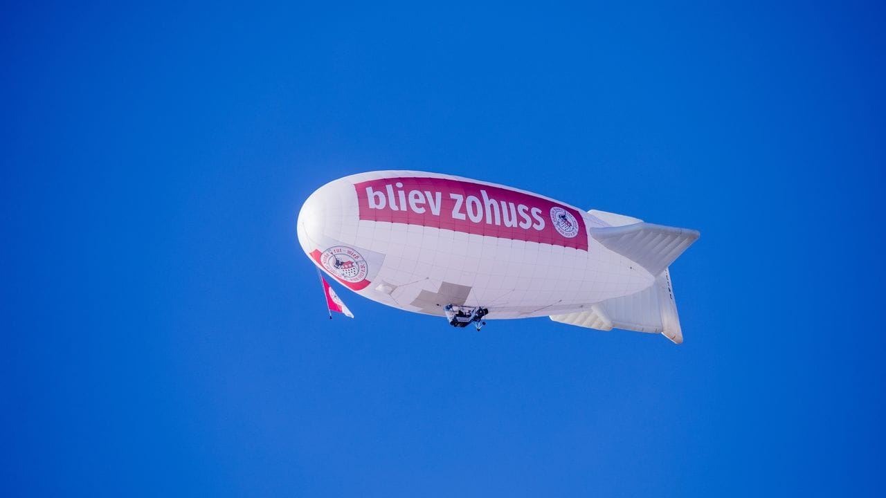 Ein Zeppelin des Karnevalscorps Rote Funken fliegt über Köln: Darauf ist die Aufschrift "bliev zohuss" (Kölsch für "Bleib zu Hause") zu lesen.