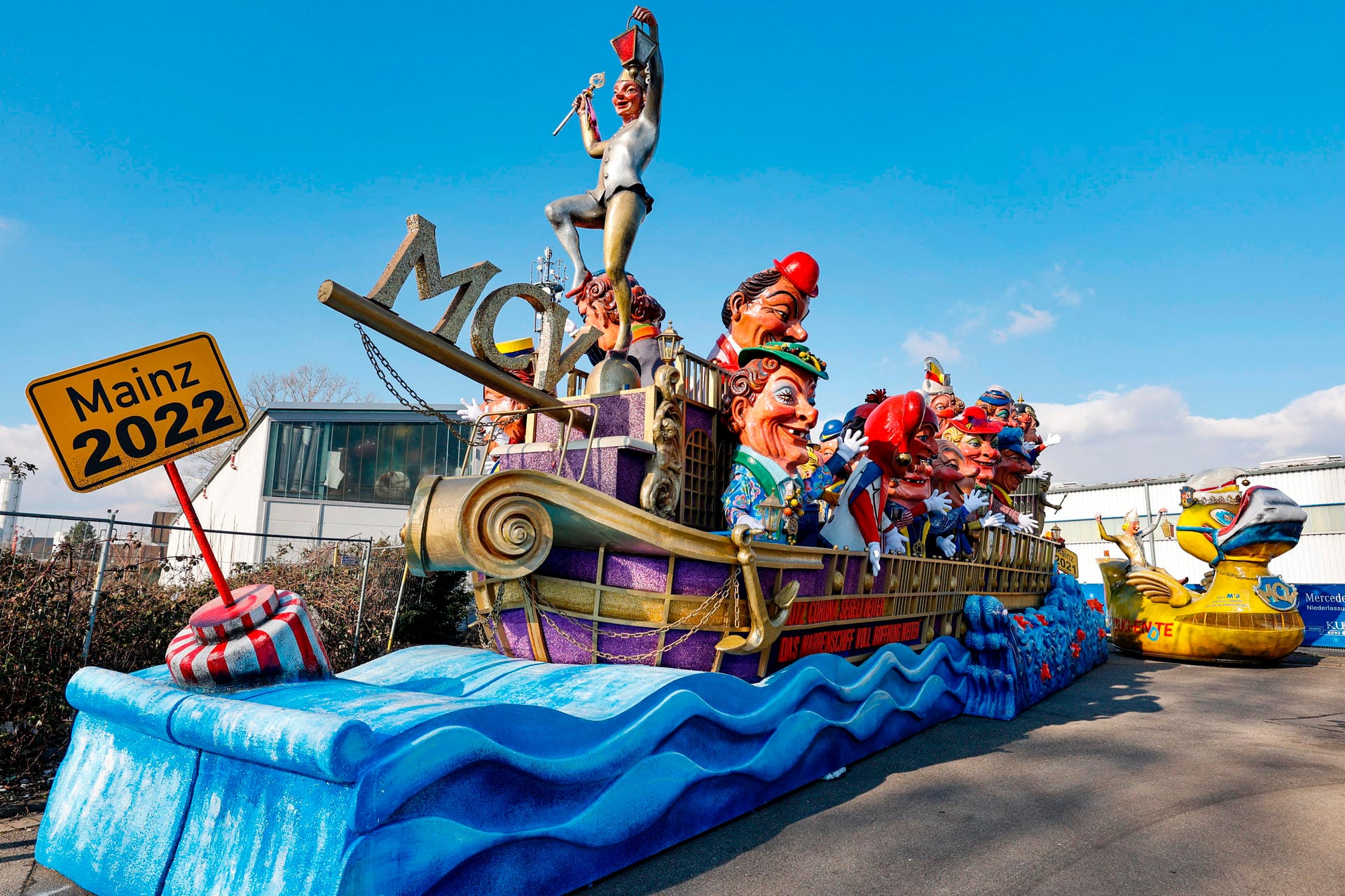 Ein Umzugswagen des Mainzer Carnevals-Vereins zeigt ein riesiges Narrenschiff, weit über zehn Meter lang, das von Wellen umspült mit unzähligen Pappmacheköpfen besetzt ist und die Botschaft sendet: "Trotz Corona segelt heiter, das Narrenschiff voll Hoffnung weiter."