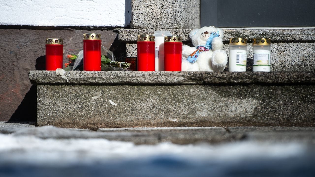 Nachbarn bringen ihre Trauer mit Kerzen und einem Teddybär zum Ausdruck.