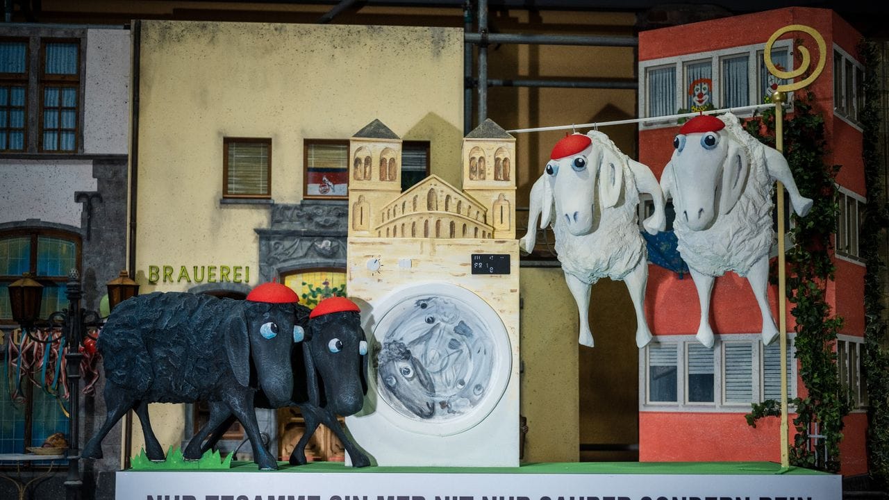 Weiße und schwarze Schafe in der Kirche: Miniaturkarnevalswagen in Köln.