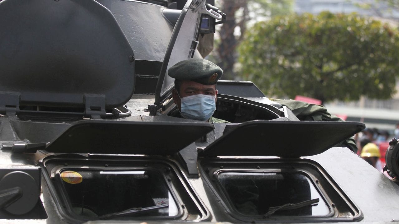 Ein Soldat schaut in Rangun aus einem gepanzerten Militärfahrzeug heraus, das vor dem Gebäude der Zentralbank steht.