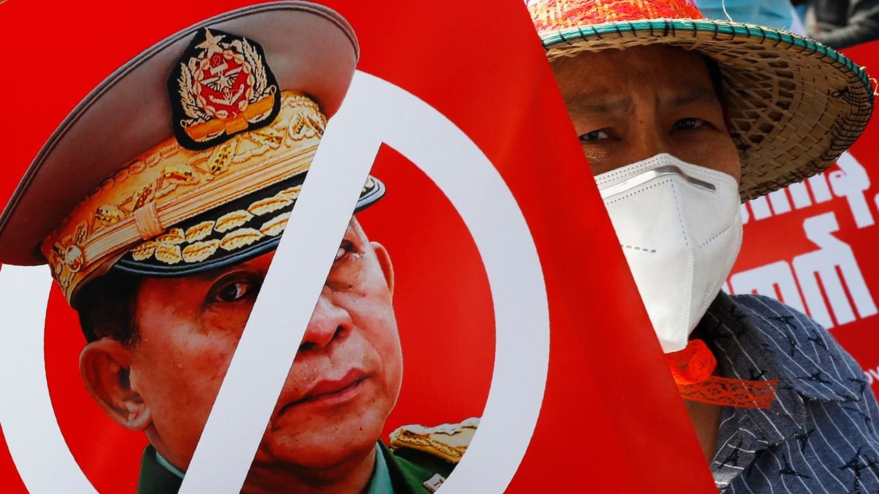 Ein Demonstrant hält ein Plakat mit einem durchgestrichenen Porträt von General Min Aung Hlaing, dem Anführer der Putschisten.