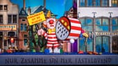 Ein Miniaturkarnevalswagen, der einen Narren mit einer Trommel und einem Schild mit der Aufschrift "Einsamkeit ist so scheiße" zeigt, steht im Hänneschen-Theater.