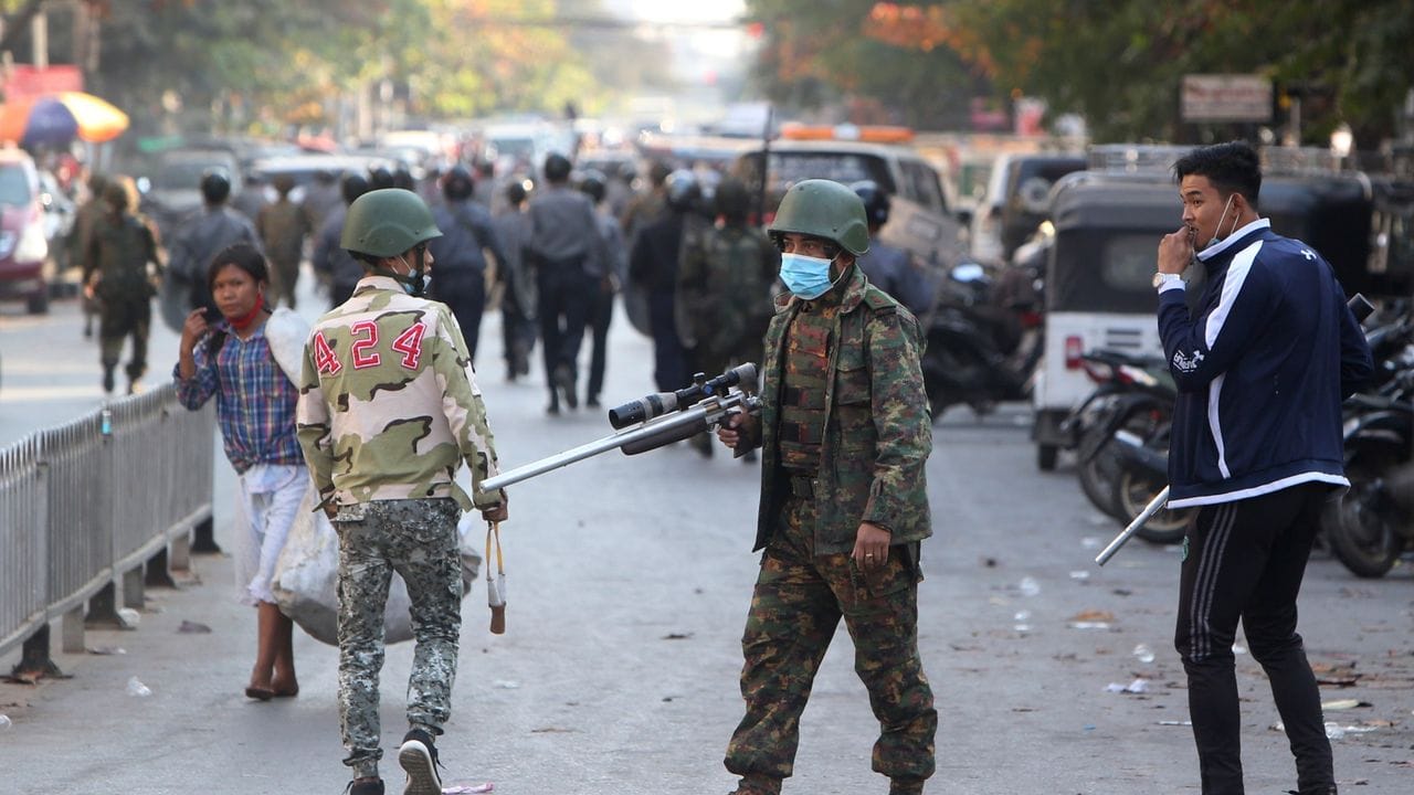 Ein bewaffneter Soldat steht bei Zusammenstößen mit Teilnehmern einer Demonstration in Mandalay.