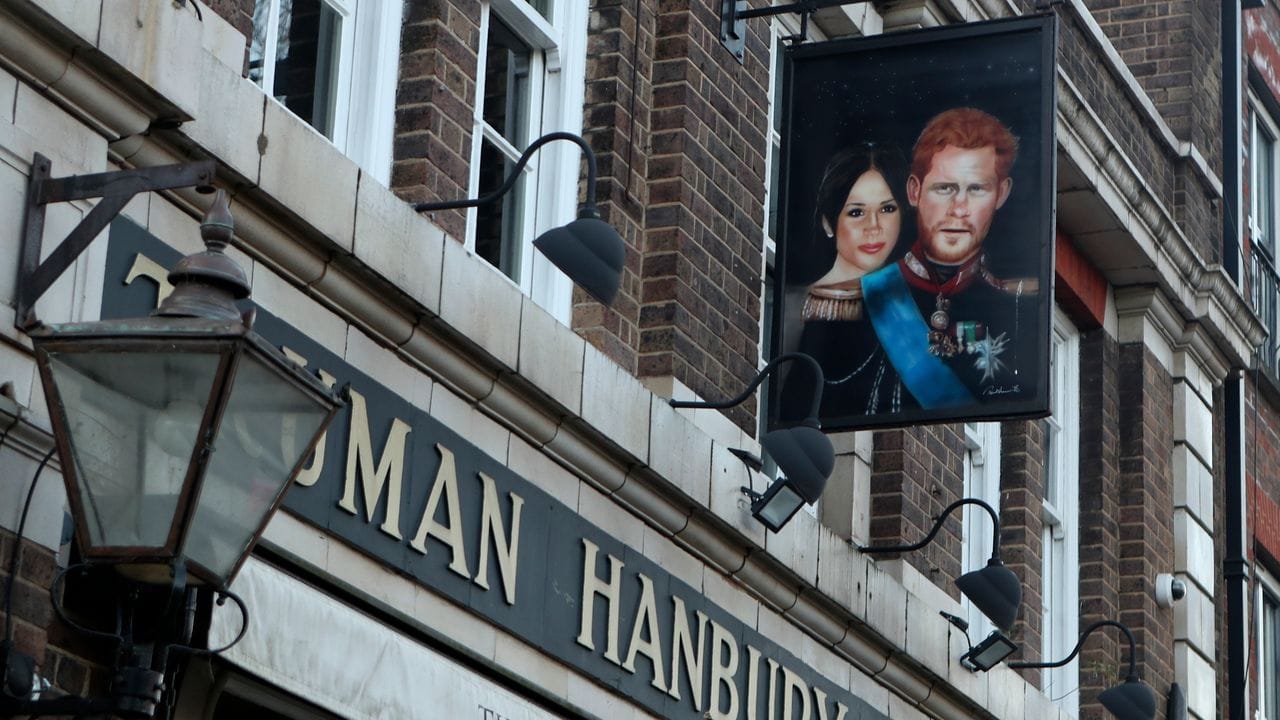 Ein Schild, das Prinz Harry und seine Frau Meghan zeigt, vor dem Pub "The Duke of Sussex" in London. Ein Schild, das Prinz Harry und seine Frau Meghan zeigt, vor dem Pub "The Duke of Sussex" in London.