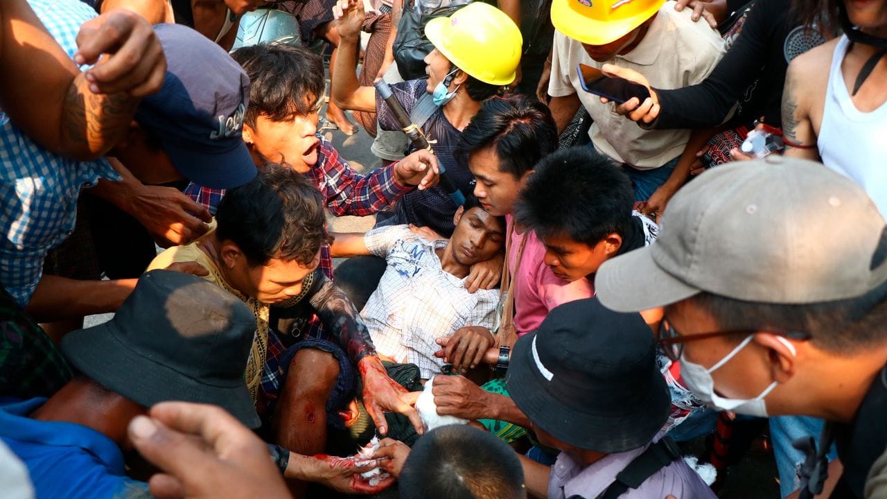 Demonstranten umringen einen Verletzten bei einem Protest gegen den Militärputsch in Yangon.