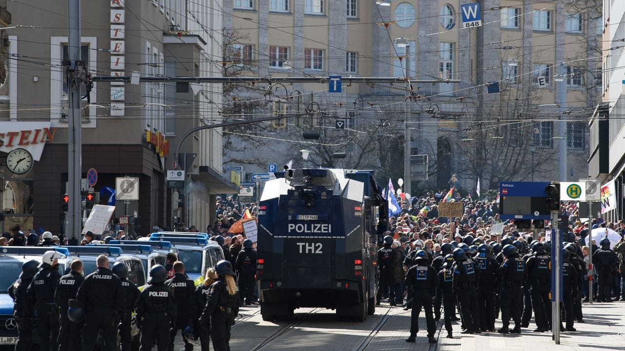 Einsatzkräfte der Polizei stehen bei einer Kundgebung unter dem Motto "Freie Bürger Kassel - Grundrechte und Demokratie" neben einem Wasserwerfer. Einsatzkräfte der Polizei stehen bei einer Kundgebung unter dem Motto "Freie Bürger Kassel - Grundrechte und Demokratie" neben einem Wasserwerfer.