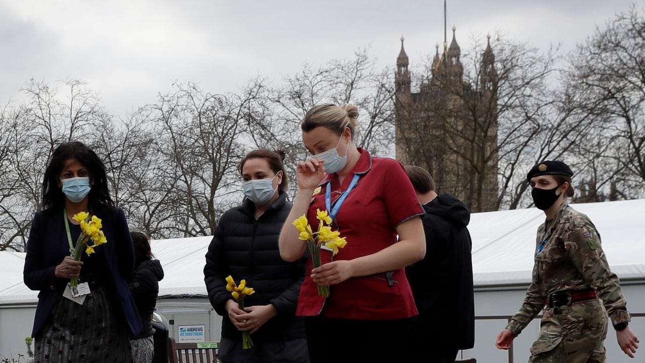 Mitarbeiterinnen des britischen Gesundheitsdienstes NHS gedenken am St Thomas' Hospital der Corona-Toten.