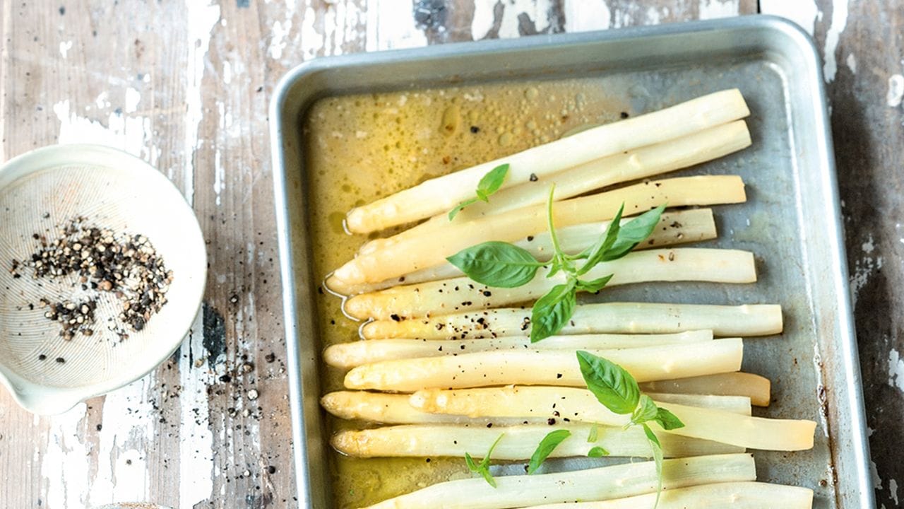 Warum nicht mal Spargel im Ofen garen? Er brutzelt dort 40 Minuten in einem Gemüsefond.