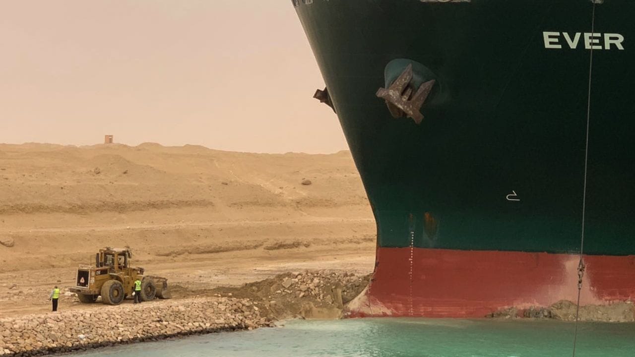 Ein Bagger versucht, das vordere Ende des havarierten Containerschiffs zu befreien.
