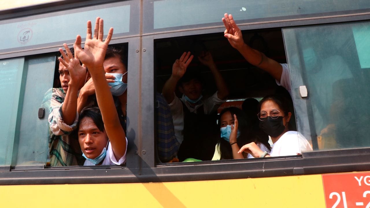 Festgenommene Demonstranten winken Menschen, während sie in einem Bus sitzen, der aus dem Insein-Gefängnis kommt und sie zu einem ungenannten Ort transportieren wird.