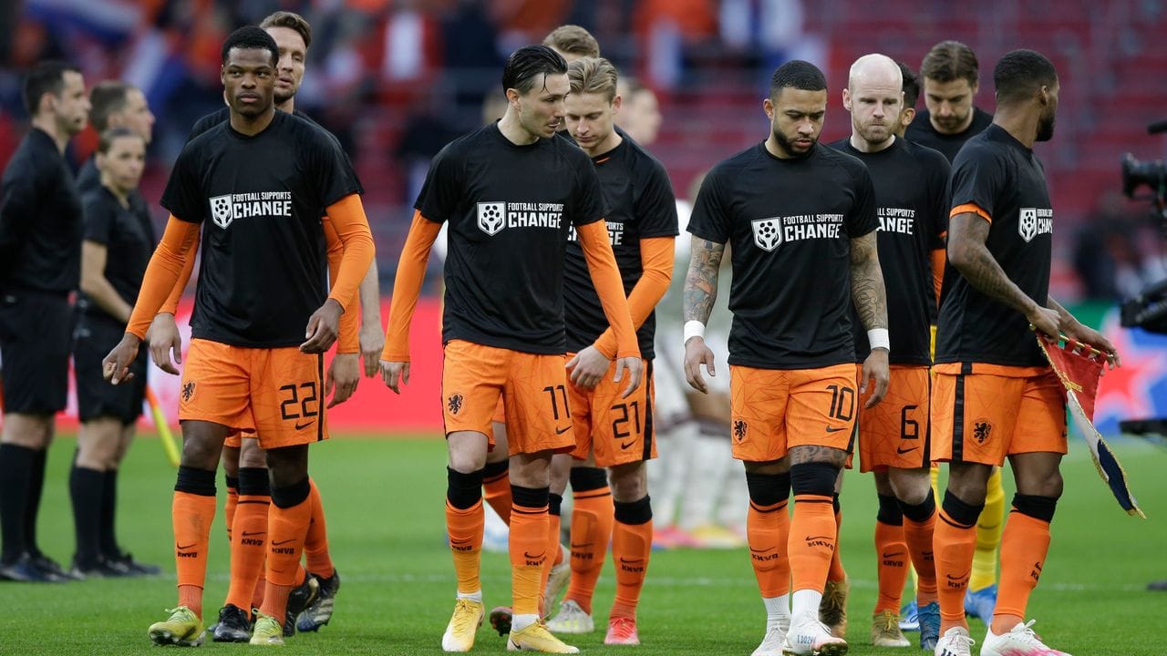 Niederländische Spieler betreten das Spielfeld mit T-Shirts mit der Aufschrift "Football Supports Change".
