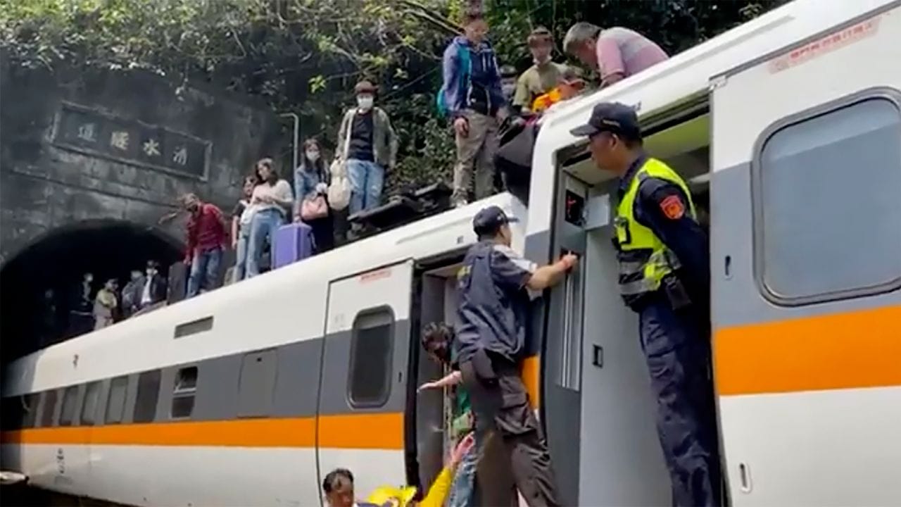 Passagieren wird geholfen, aus dem entgleisten Zug zu klettern.