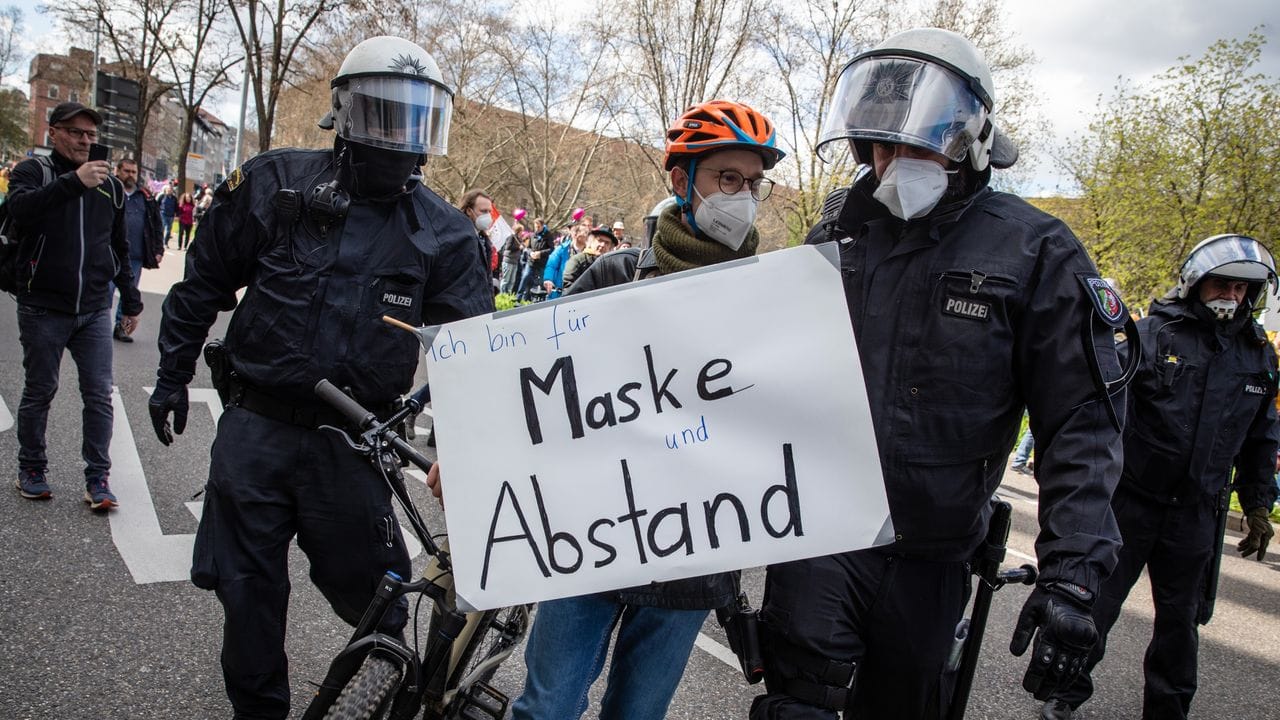 "Ich bin für Maske und Abstand" steht auf dem Schild eines Gegendemonstranten. "Ich bin für Maske und Abstand" steht auf dem Schild eines Gegendemonstranten.
