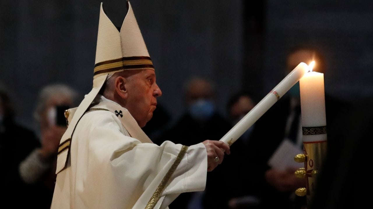 Der Pontifex trägt die Osterkerze - das Licht Christi - in den dunklen Petersdom.