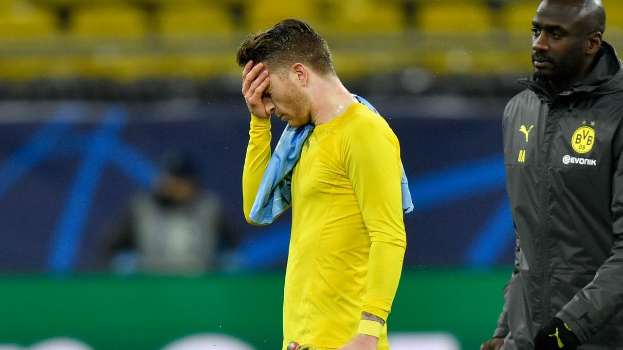 Dortmunds Kapitän Marco Reus (l) verlässt traurig den Platz.