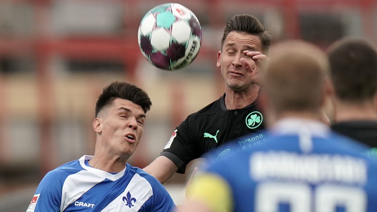 Darmstadts Mathias Honsak (l) und Fürths Paul Seguin versuchen beide per Kopf an den Ball zu kommen.