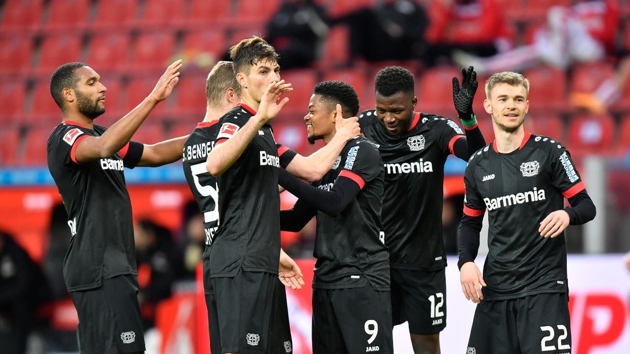 Leverkusens Stürmer Leon Bailey (M) feiert sein Tor zum 3:0 mit seinen Mitspielern.