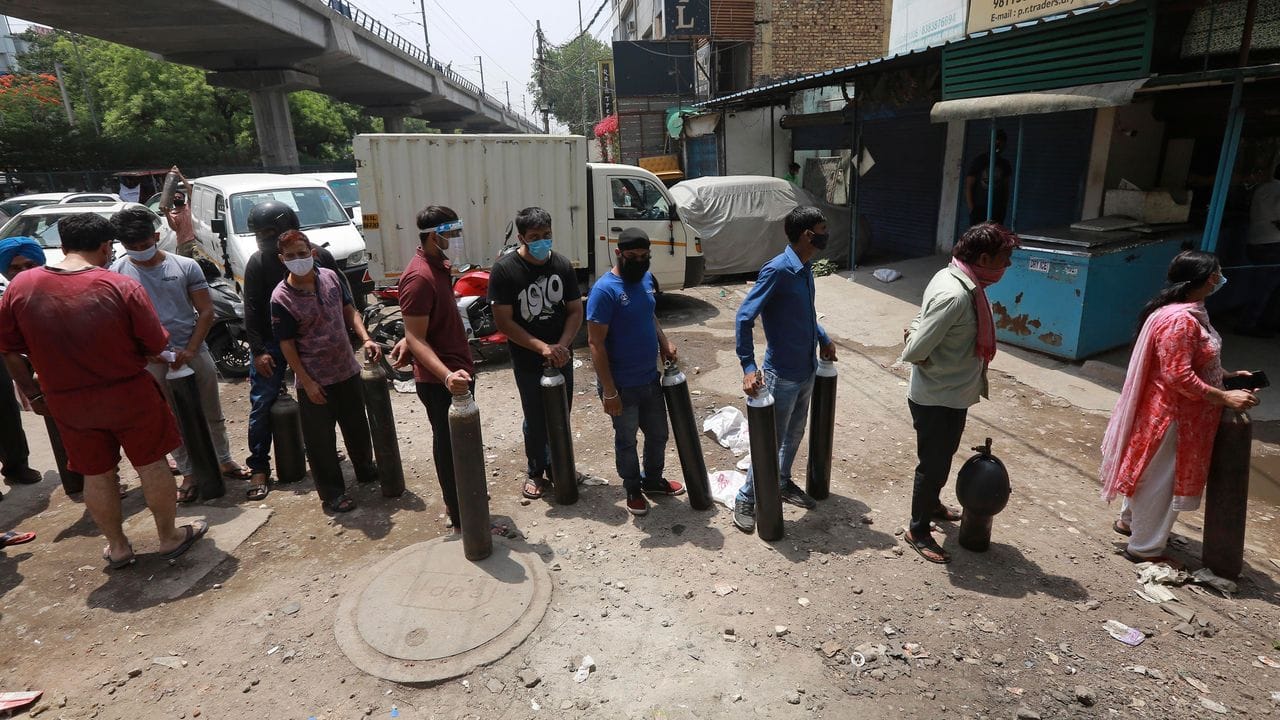Menschen stehen in Neu-Delhi Schlange, um Sauerstoffflaschen aufzufüllen.