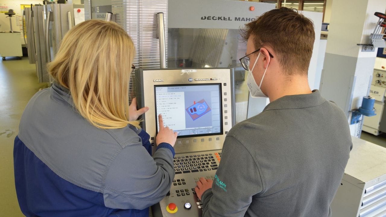 Technische Unterstützung: Pascal Scheu und seine Ausbilderin Vanessa Gfell sehen sich gemeinsam die Arbeitsschritte an der Fräsmaschine an.