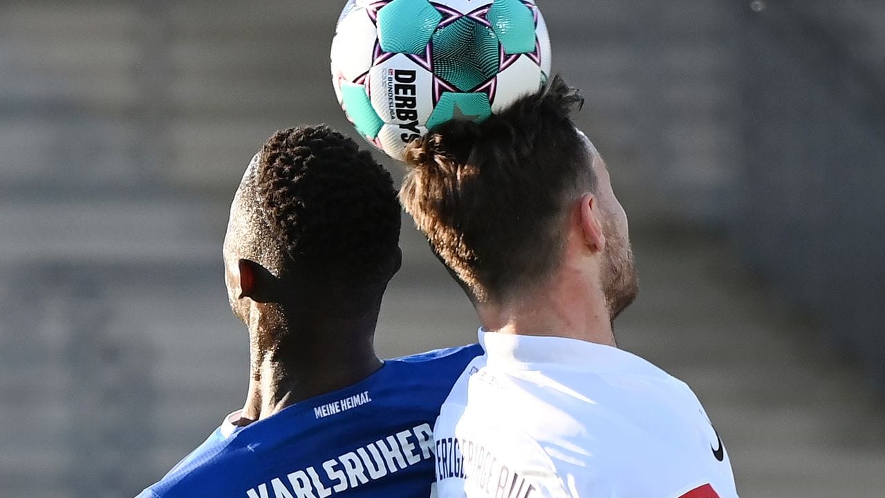 Babacar Gueye (l) vom Karlsruher SC und der Auer Florian Ballas kämpfen um den Ball.