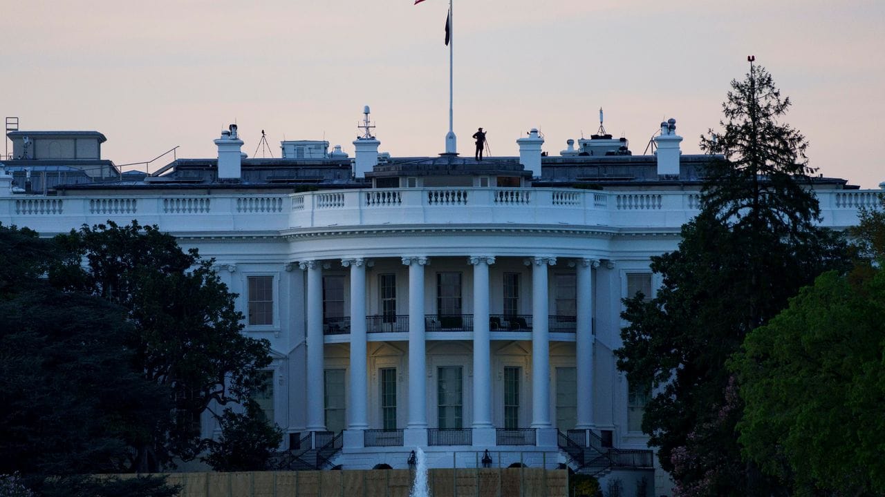 Die Flagge der USA weht bei Sonnenaufgang über dem Weißen Haus. Die Flagge der USA weht bei Sonnenaufgang über dem Weißen Haus.
