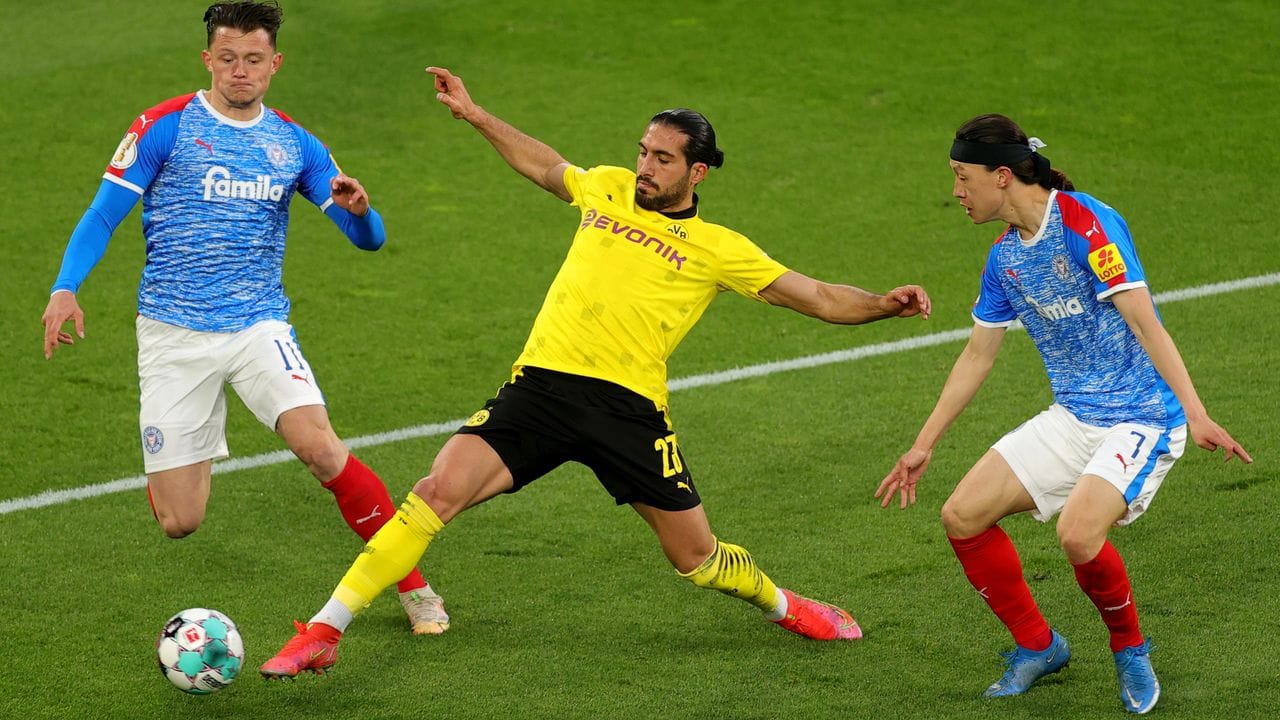 Dortmunds Emre Can (M) kommt vor Kiels Fabian Reese (l) an den Ball.