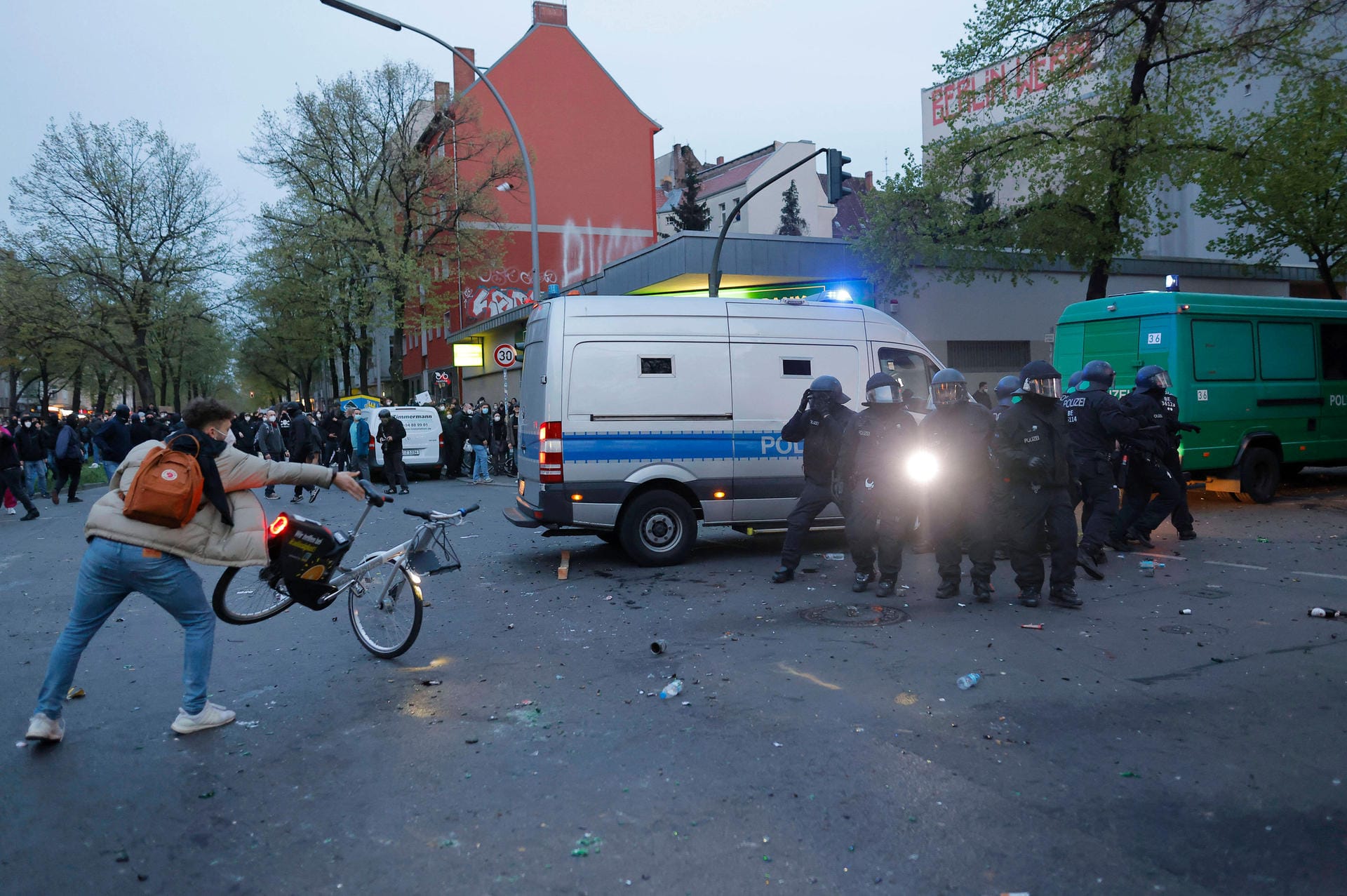 Ein Randalierer schmeißt ein Fahrrad in Richtung von Polizeibeamten: Aus der Menge heraus hat es immer wieder Angriffe auf Polizisten gegeben.