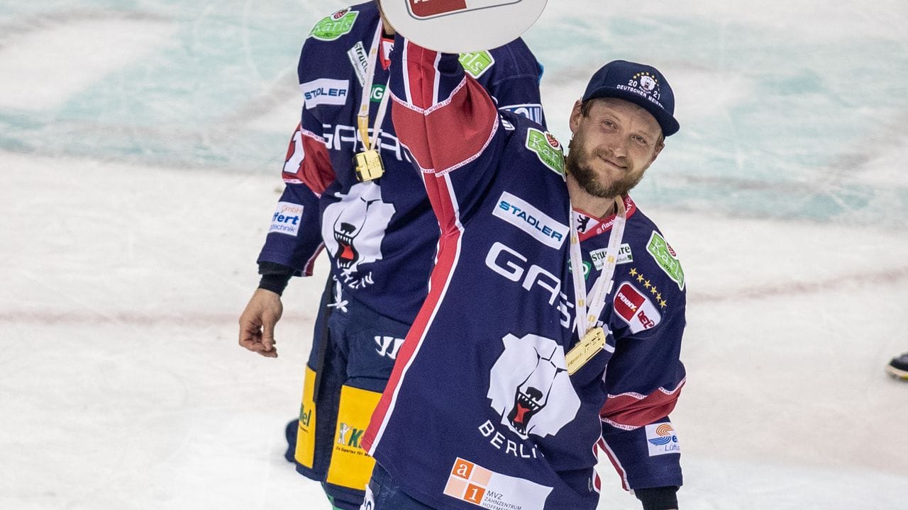 Frank Hördler fährt mit dem Pokal über das Eis.