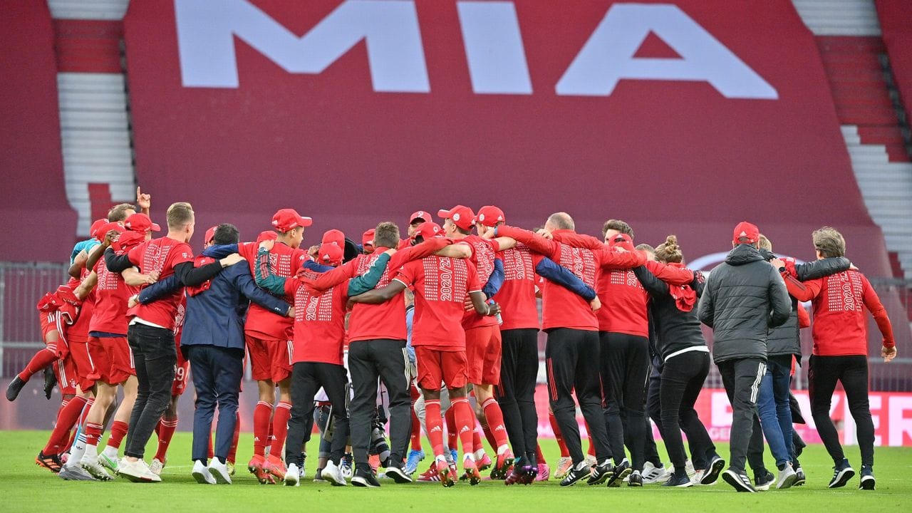 Bayerns Spieler feiern nach Spielende die Deutsche Meisterschaft auf dem Rasen der leeren Allianz Arena.