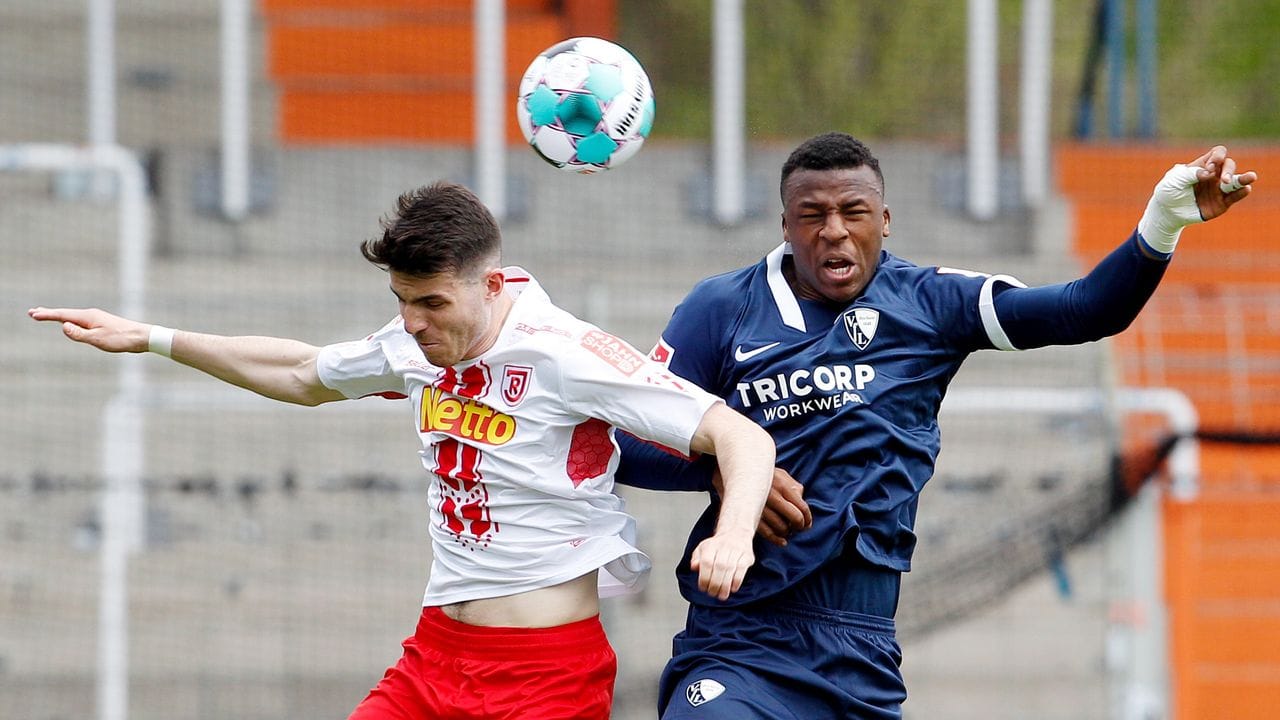 Der Bochumer Armel Bella-Kotchap (r) und der Regensburger Kaan Caliskaner kämpfen um den Ball. Der Bochumer Armel Bella-Kotchap (r) und der Regensburger Kaan Caliskaner kämpfen um den Ball.